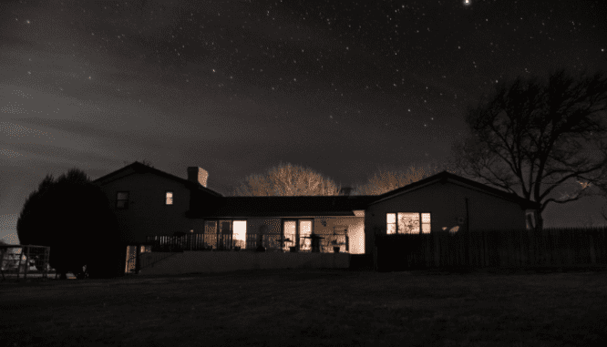 An image of a house at night used to show the importance of crime reports in your neighborhood.