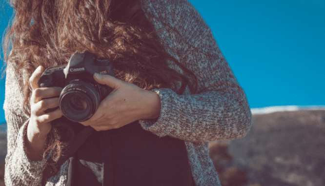 A person with a camera taking pictures of a home.