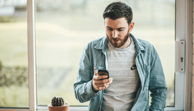 A man holding a phone to demonstrate how to find a good listing agent.