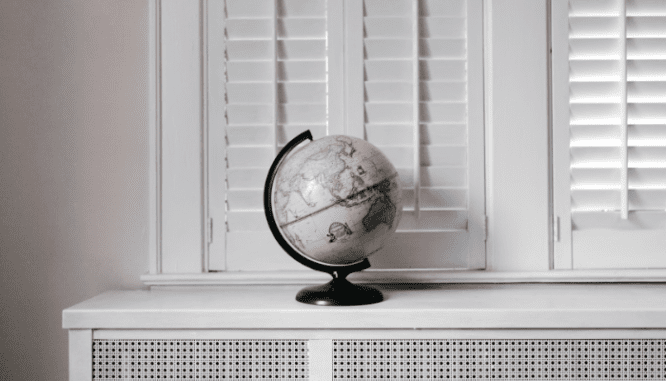 A globe in a home with gray paint.