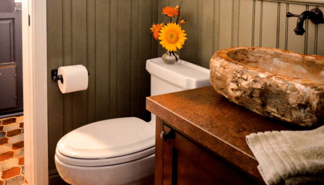 A vanity and toilet with flowers used to demonstrate powder room ideas.