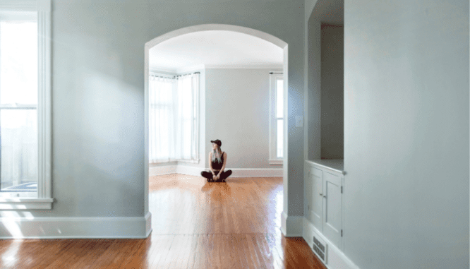 An image of a woman in an empty house meant to depict selling a rental property.