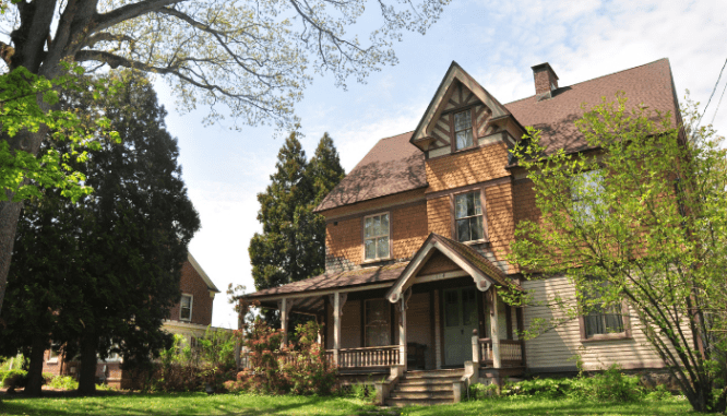 A house with trees and sky to demonstrate the process of selling a rental property.