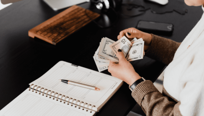 A woman counting cash to be contributed to a short sale.