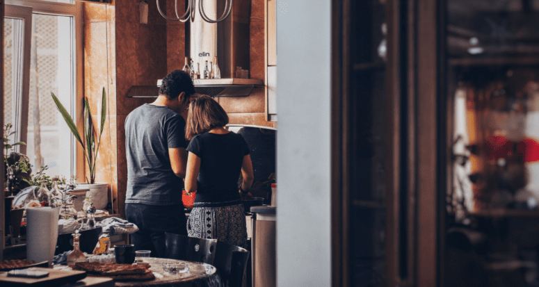 A man and a woman standing in a kitchen to demonstrate how homeowners insurance works.