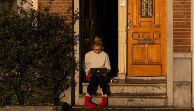 An image of a woman searching online for how homeowners insurance works.