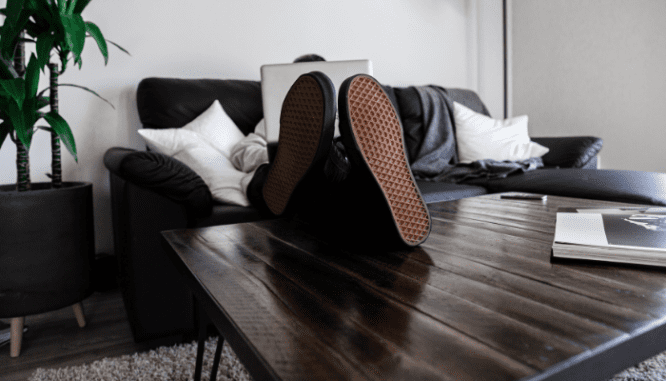 An image of a man sitting on a couch to demonstrate the value of adding an egress window to your home.