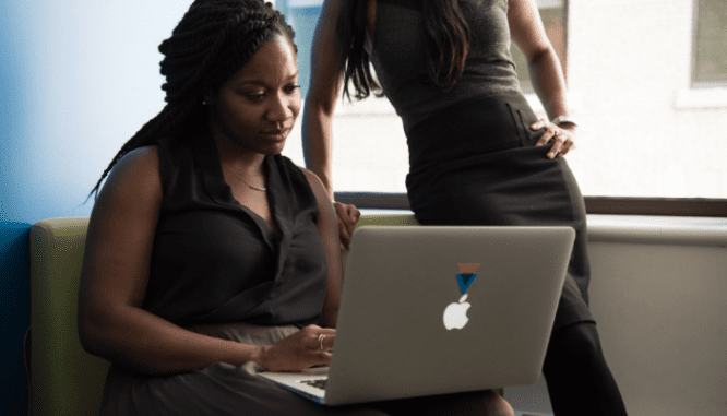 An image of two women looking at a computer to demonstrate money saving tips for buying a home.