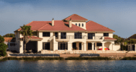 An image of a house on the water to demonstrate different types of real estate investments.