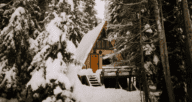 An image of an A-frame house in snowy mountains to depict what an A-frame house is.