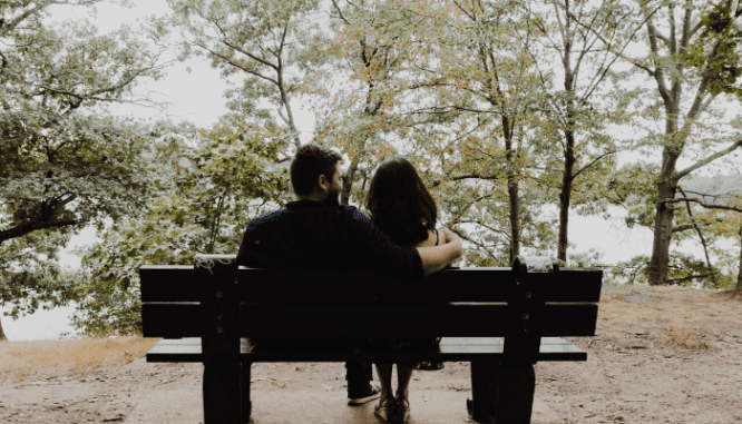 A couple sitting on a bench, thinking about buying a house in Calabasas.