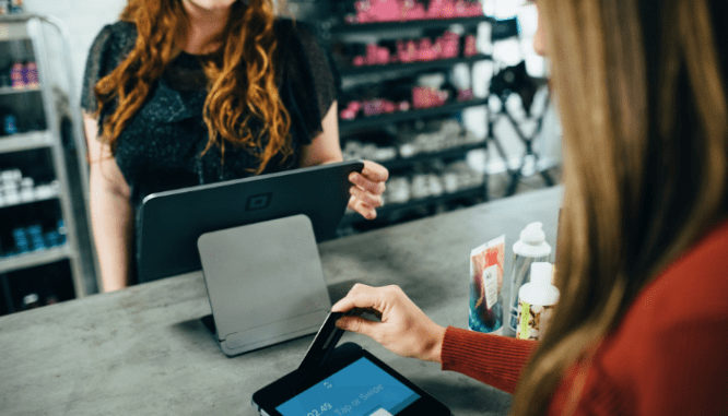 A woman using a credit card to build her credit score for a home loan.