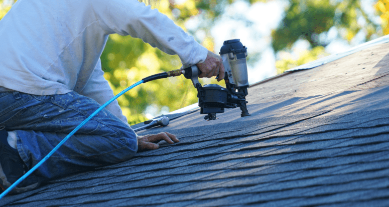 An image of a roof repairman working to demonstrate how much it would cost to replace a roof.