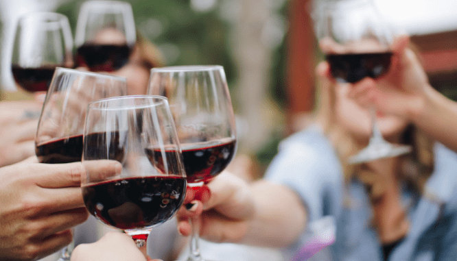 People toasting with glasses of wine at a housewarming party.