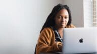 A woman using a computer to buy a home as-is.