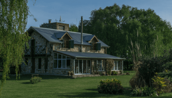 An image of a house with a lawn to demonstrate if you can short sell your house and buy another.