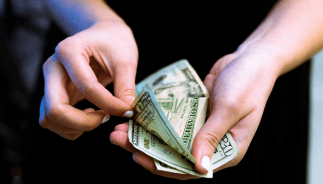 a person counting the money they will need to set aside for their house downpayment.