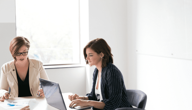 An image of two women in a meeting to demonstrate how to make an offer on a house with a realtor.