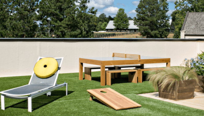 A rooftop patio with corn hole and ping ping tables.