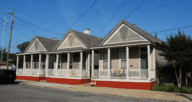 Three shotgun houses lined together in the city.