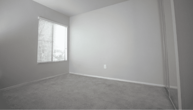 An empty room that is 10x12 and has been carpeted.