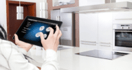 A tablet is used to control various appliances in a smart kitchen.