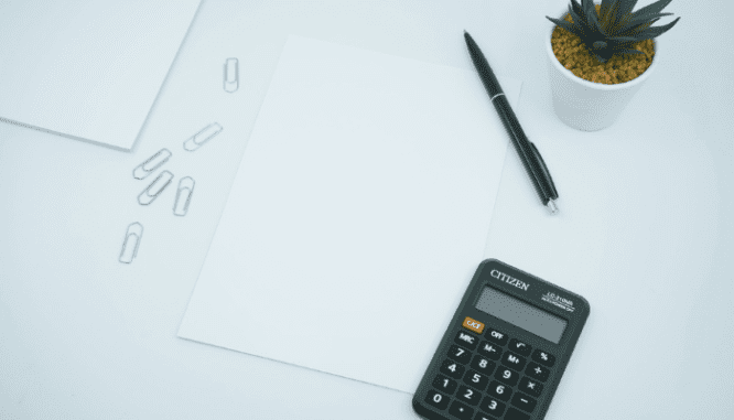 A calculator and paper to calculate a monthly mortgage payment.