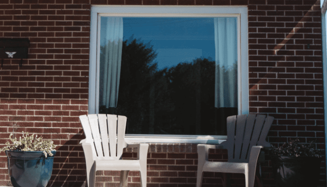 Two chairs in front a home that has net-zero emissions.