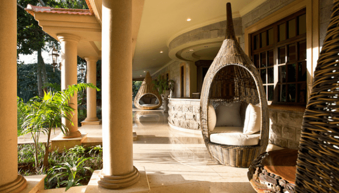 A modern porch with swings in an outdoor room.