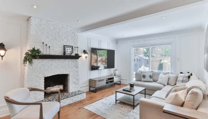 A neutral living room with fireplace, that could attract buyers if you repaint before selling.