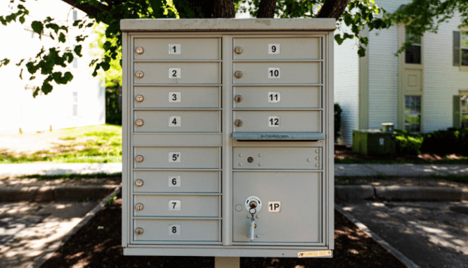 A community mailbox with a letter enforcing hoa rules inside.