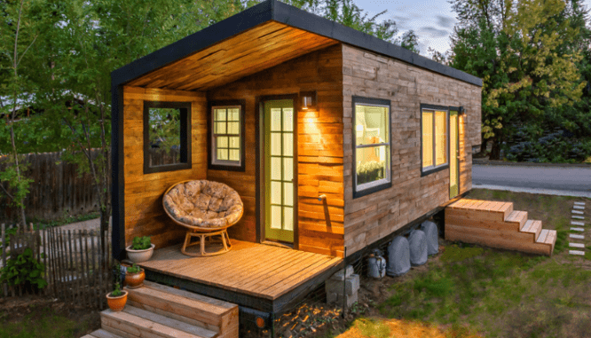 A tiny house that is illuminated at night.