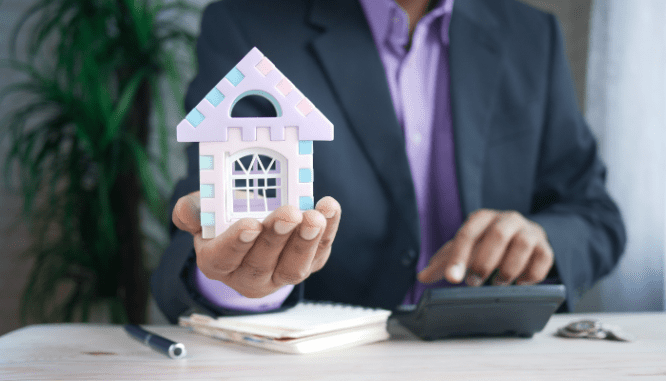 A man holding a toy house, which represents the homes you could buy using different kinds of mortgages.