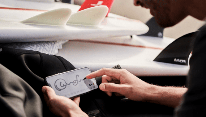 A man signing closing documents on his phone as a buyer.