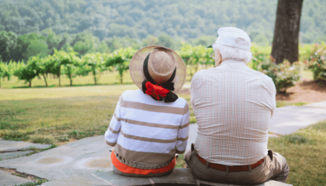 Seniors sitting on a bench in an area near their Realtor.