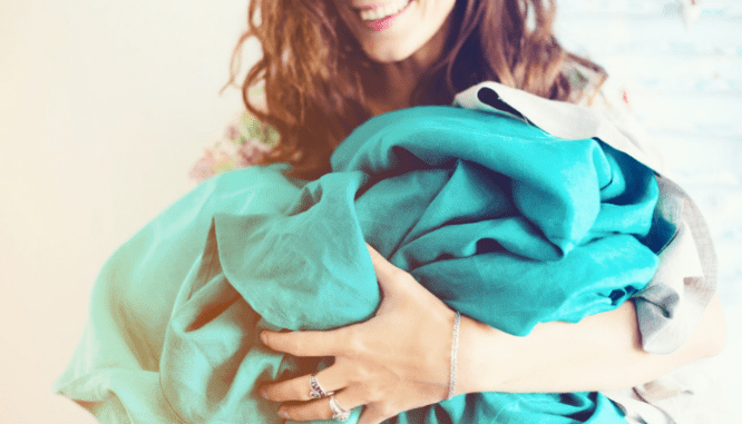 A woman using linens to pack fragile items to make moving easier.