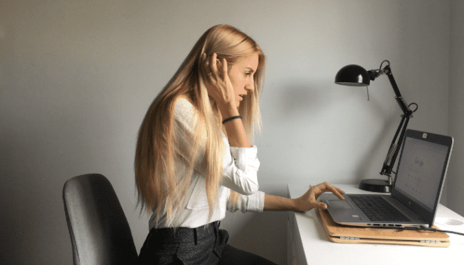 A woman using her laptop to research what the most important things to fix are when selling a house.