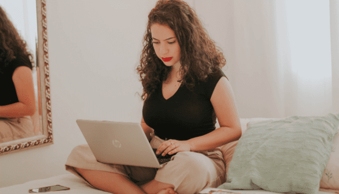 A homeowner using her laptop to research if she should get an appraisal before selling her house.