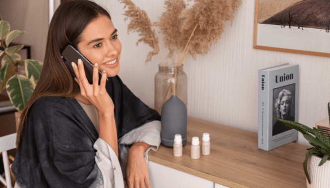 A woman talking to a real estate agent on the phone to see if a gated community is right for her.