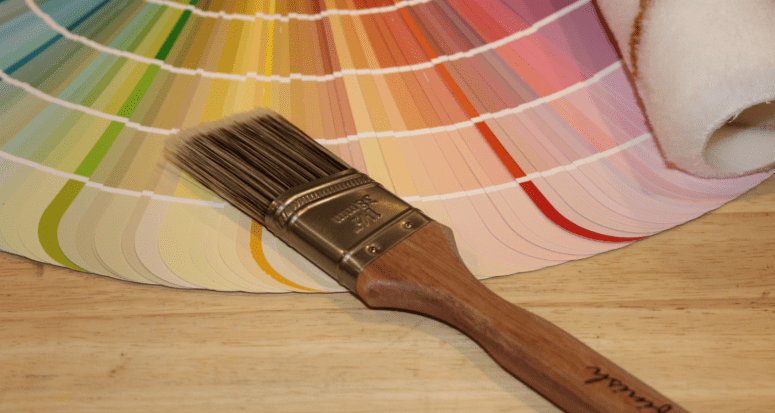 A color wheel and paintbrush to help select the best bedroom colors to sell a house.