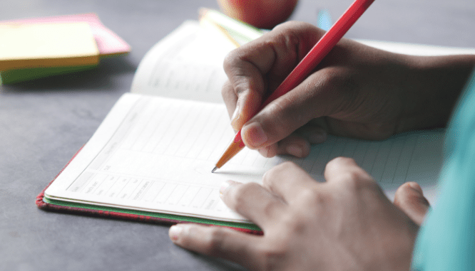 A person making notes on how to go to an open house.
