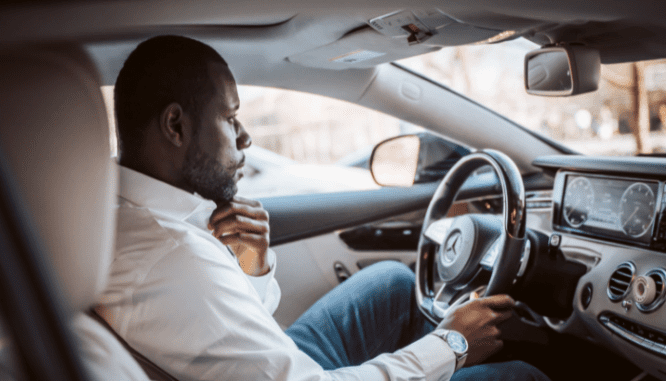 A person in their car, deciding how to go to an open house.