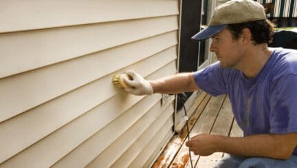 A man keeping up with his home maintenance checklist outside a home.