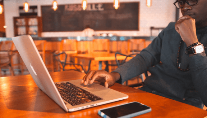 A man using a laptop to research how to buy a house in the military.