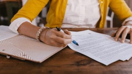 a real estate agent holds the closing checklist paperwork at the end of a home sale