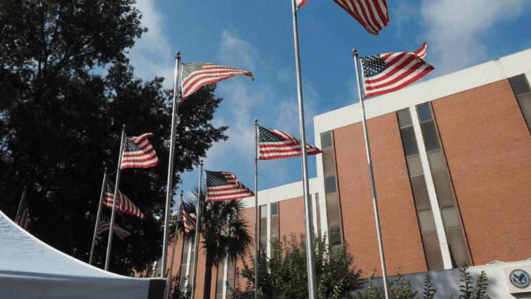 American flags in front of a building that provides military selling house programs.