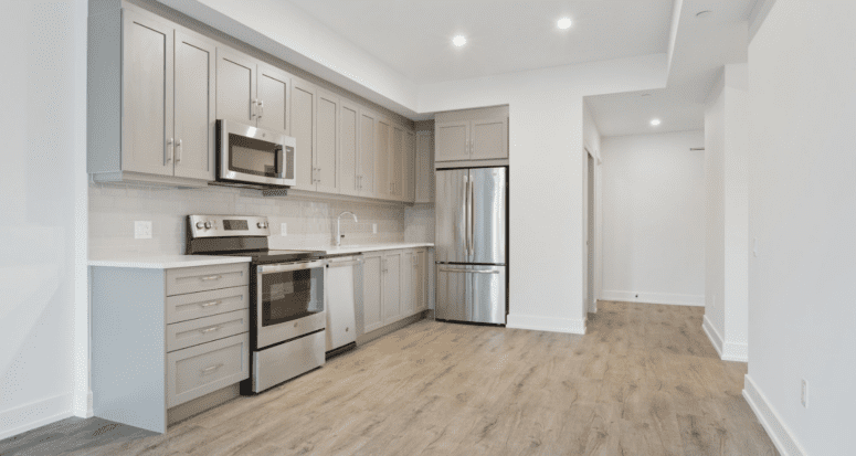 A kitchen in a house trying to sell with broken appliances.