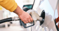 A man pumping gas while the prices are affecting the housing market.