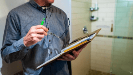 A man with a clipboard performing a free home inspection.