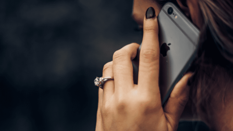 A woman using a phone to interview a real estate agent.